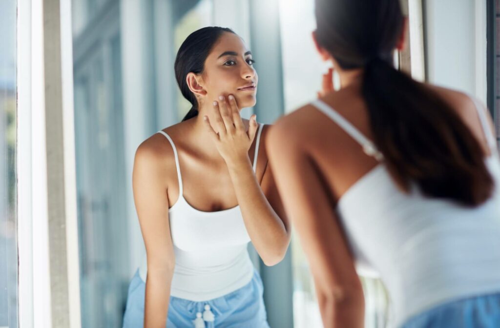 Someone examines the results of their RF microneedling treatment in a mirror.