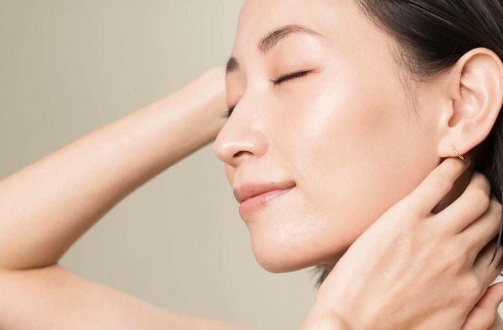 A close-up side profile of an individual with their eyes closed, showcasing clear and healthy skin texture.